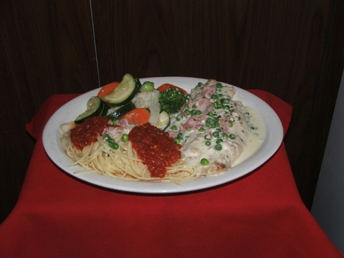 Pollo Franciscano. Chicken with green peas, prosciutto and cream sauce.